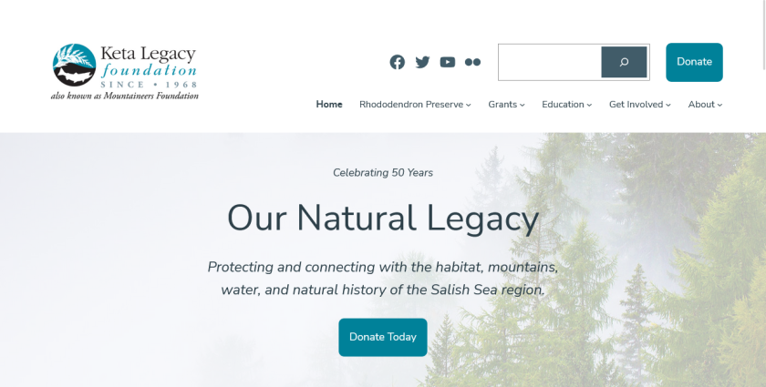 The Keta Legacy Foundation is a very light, with a grayed-out photo of evergreens in thick fog beneath a large motto: "Our Natural Legacy."