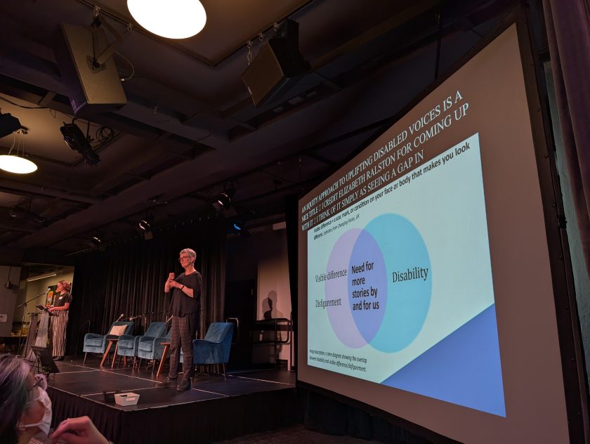 Slide with venn diagram. Left side: visible difference, disfigurement. Right side: Disability. Overlapping middle: Need for more stories by and for us. Speaker and ASL interpreter in background on left